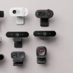 Várias webcams profissionais lado a lado sobre superfície neutra, representando a escolha da melhor opção para home office e reuniões