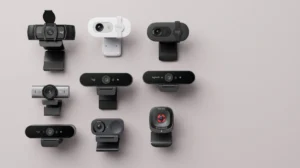 Várias webcams profissionais lado a lado sobre superfície neutra, representando a escolha da melhor opção para home office e reuniões