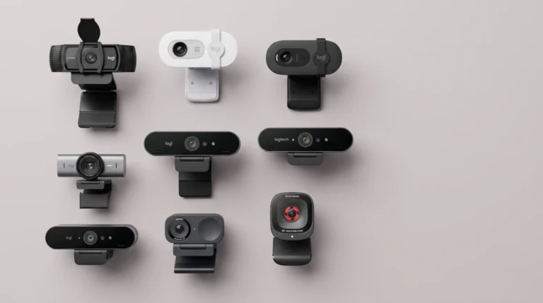 Várias webcams profissionais lado a lado sobre superfície neutra, representando a escolha da melhor opção para home office e reuniões