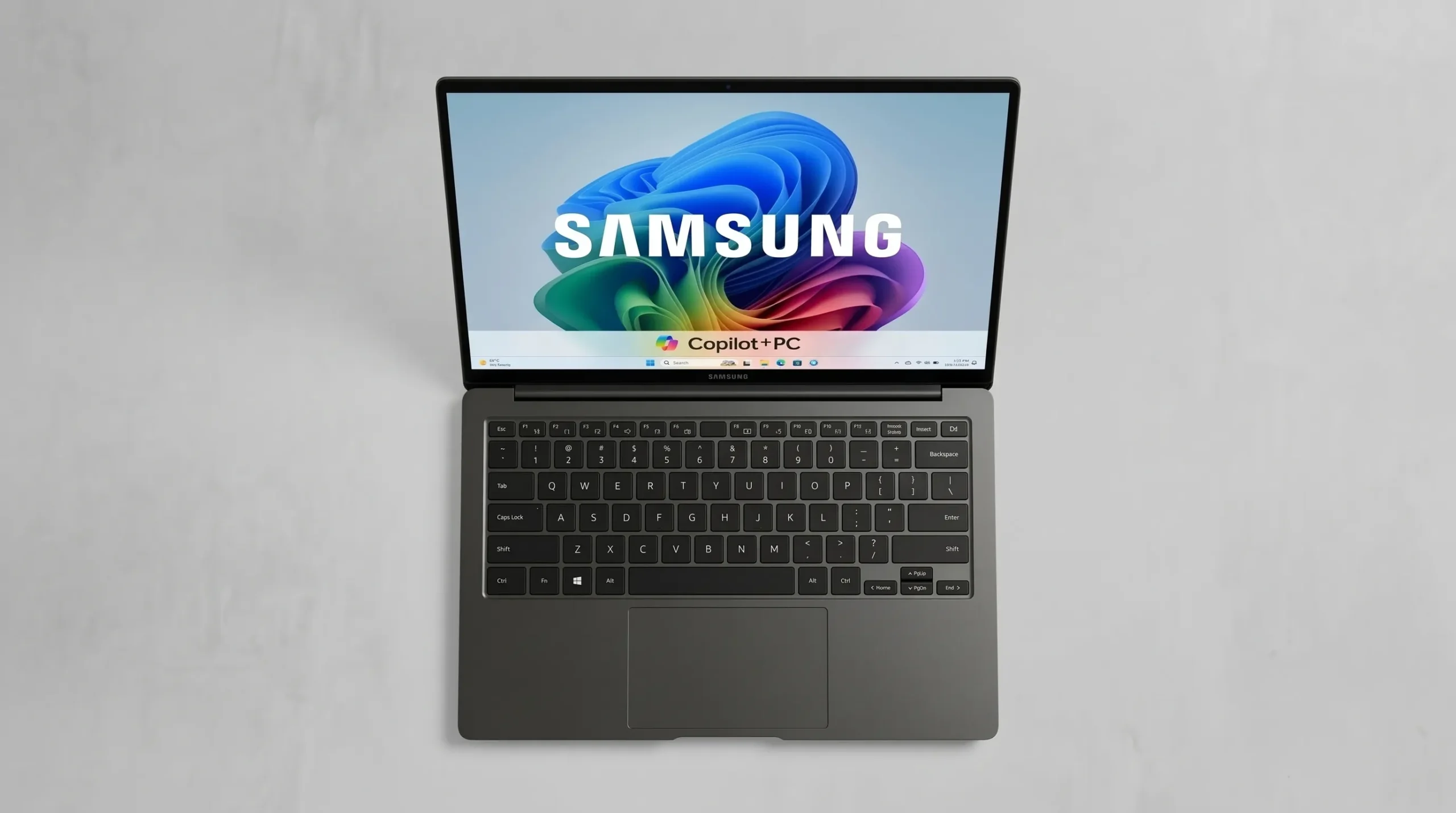 Notebook Samsung Copilot+ PC aberto, visto de cima, com o logotipo Samsung na tela e teclado cinza-escuro sobre fundo claro